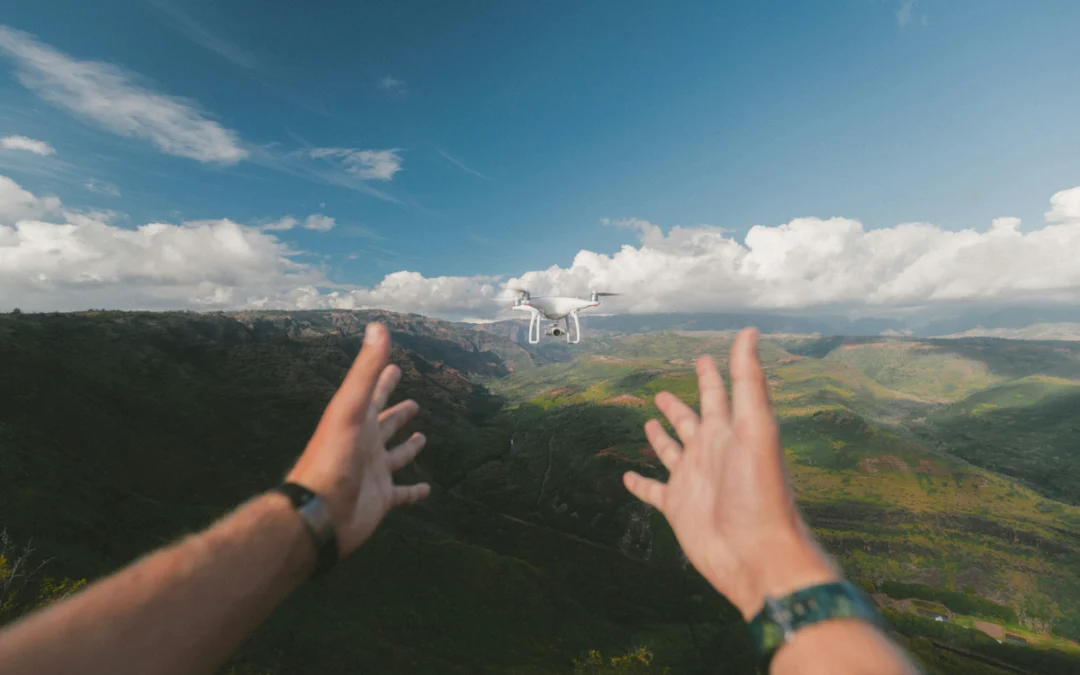 A drone flying in front of a pair of hands